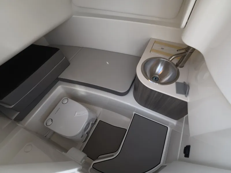 Slide: The Image of Interior of a modern boat cabin with a sink, toilet, and gray cushions. - 18