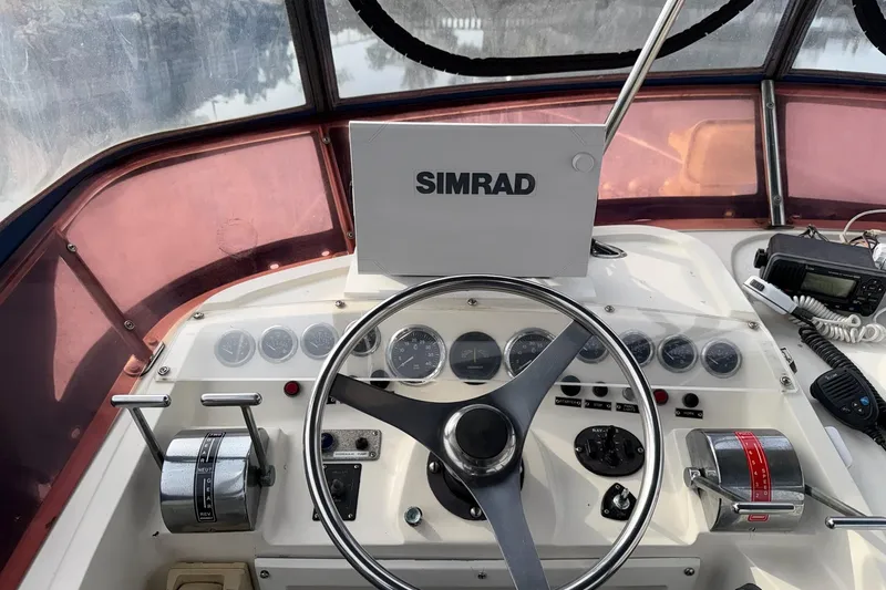 Slide: The Image of Cockpit of a 1990 Mediterranean Sport Fish boat with steering wheel and navigation equipment. - 7