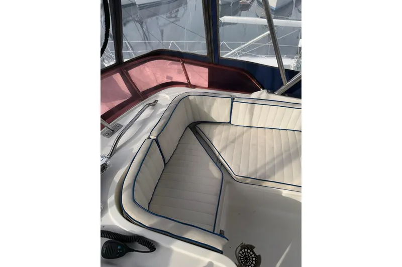 Slide: The Image of 1990 Mediterranean Sport Fish boat interior with white cushioned seating and blue trim. - 9