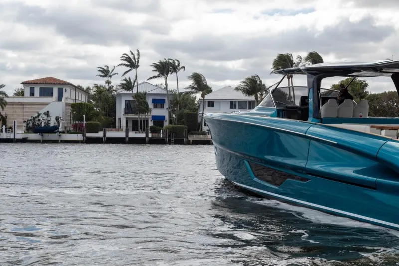 Slide: The Image of 2024 Solaris Power 52 Open yacht cruising near waterfront homes. - 12