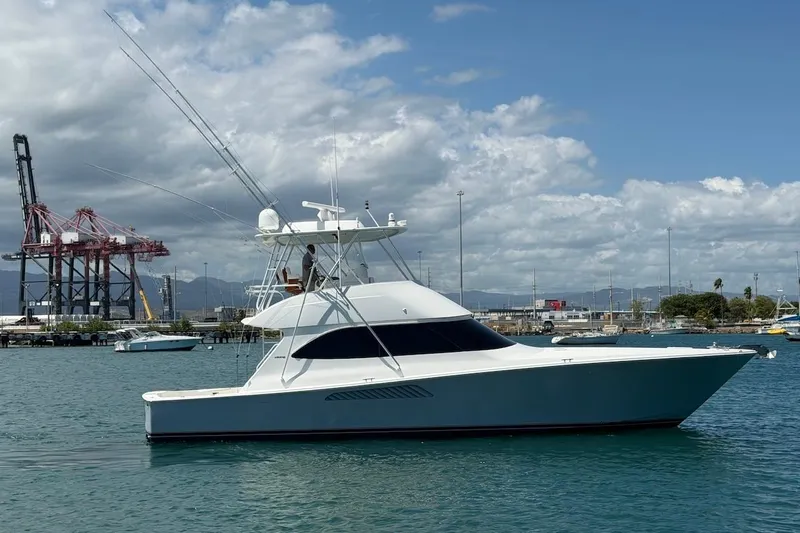 The Image of 2012 Viking 50 Convertible yacht docked in a harbor with industrial cranes in the background. - 0