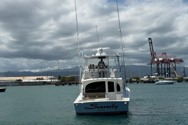 Slide: The Image of Viking 50 Convertible 2012 yacht "Sandy" in a harbor with industrial cranes. - 12