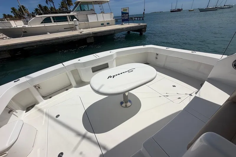 Slide: The Image of Viking 50 Convertible 2012 yacht deck with table, docked by the sea. - 18