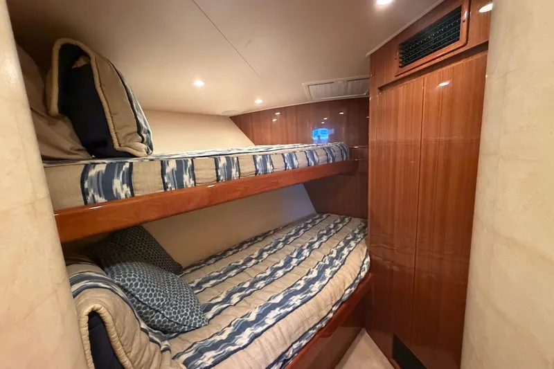 Slide: The Image of Bunk beds in 2012 Viking 50 Convertible yacht cabin with wood paneling. - 34