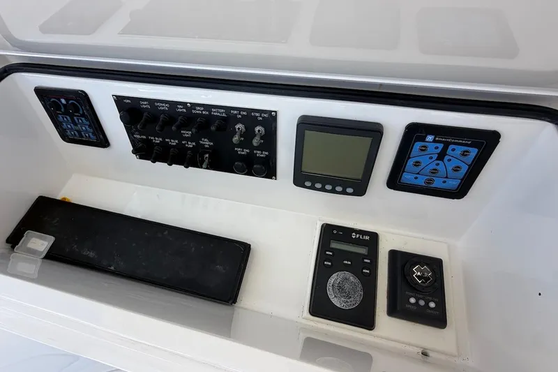 Slide: The Image of Control panel of a 2012 Viking 50 Convertible yacht with various switches and displays. - 46