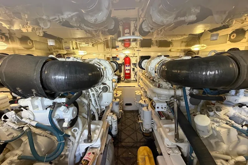 Slide: The Image of Engine room of 2012 Viking 50 Convertible yacht, featuring dual engines and fire extinguisher. - 54