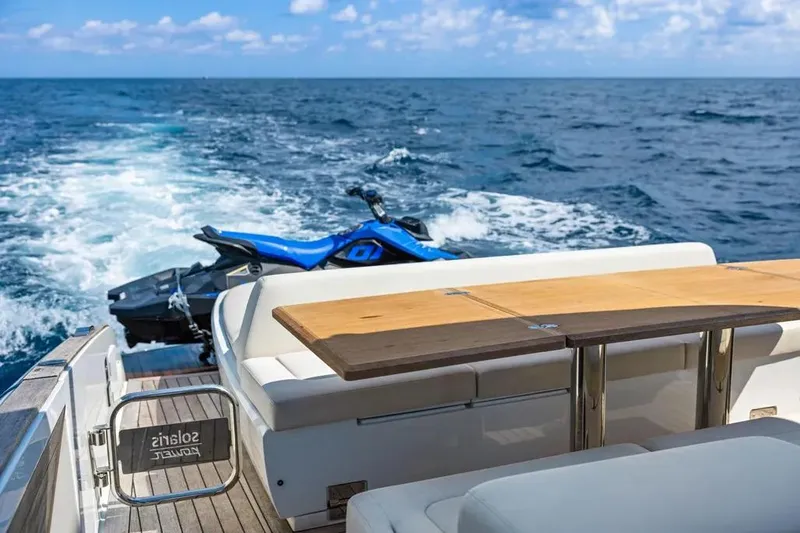 Slide: The Image of 2024 Solaris Power 44 Open yacht with jet ski on ocean, featuring luxurious seating and table. - 8