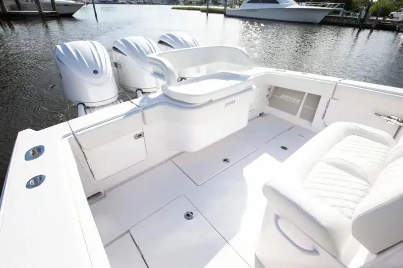 Slide: The Image of Manufacturer Provided Image: 2026 Jupiter 340LS boat with triple outboard engines, white interior, docked on calm water. - 12