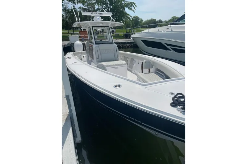 Slide: The Image of 2026 Jupiter 340LS boat docked, featuring sleek design and Garmin equipment. - 3