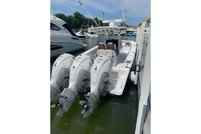 Slide: The Image of 2026 Jupiter 340LS boat with triple outboard engines docked at marina. - 4
