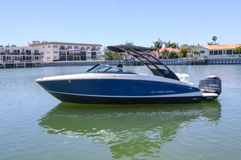 Slide: The Image of 2020 Regal LX4 boat on calm water, featuring sleek design and Yamaha outboard motor. - 1