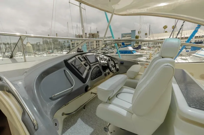 Slide: The Image of 2007 Cruisers Yachts 560 Express helm with luxurious seating and modern controls in a marina setting. - 10