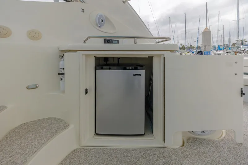 Slide: The Image of 2007 Cruisers Yachts 560 Express mini fridge in open cabinet, docked at marina. - 13