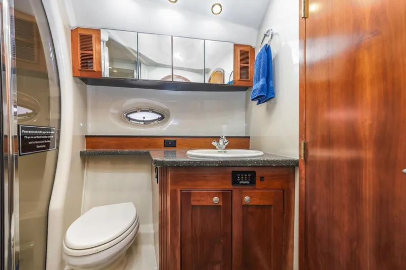 Slide: The Image of Luxurious bathroom in 2007 Cruisers Yachts 560 Express with wood cabinetry and modern fixtures. - 25
