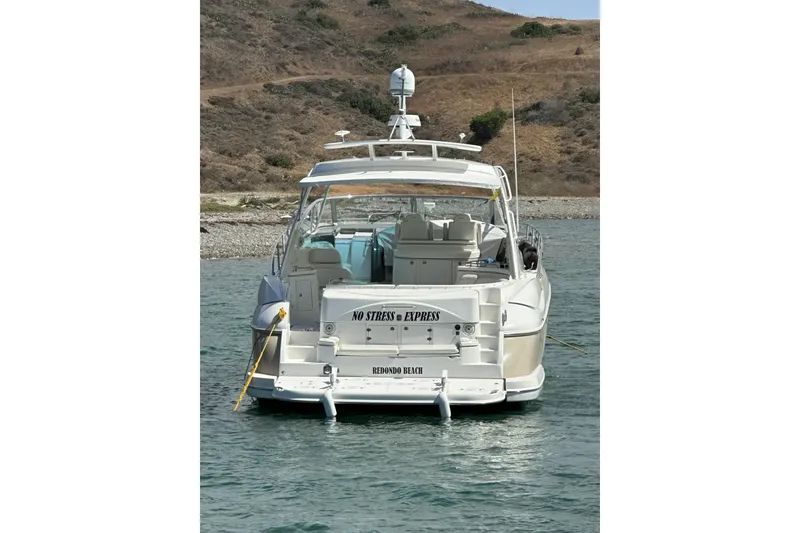 Slide: The Image of 2007 Cruisers Yachts 560 Express anchored in scenic waters near a rocky shoreline. - 3