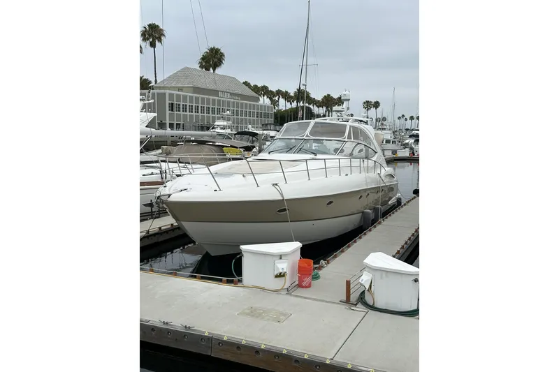 Slide: The Image of 2007 Cruisers Yachts 560 Express docked at a marina with palm trees. - 38