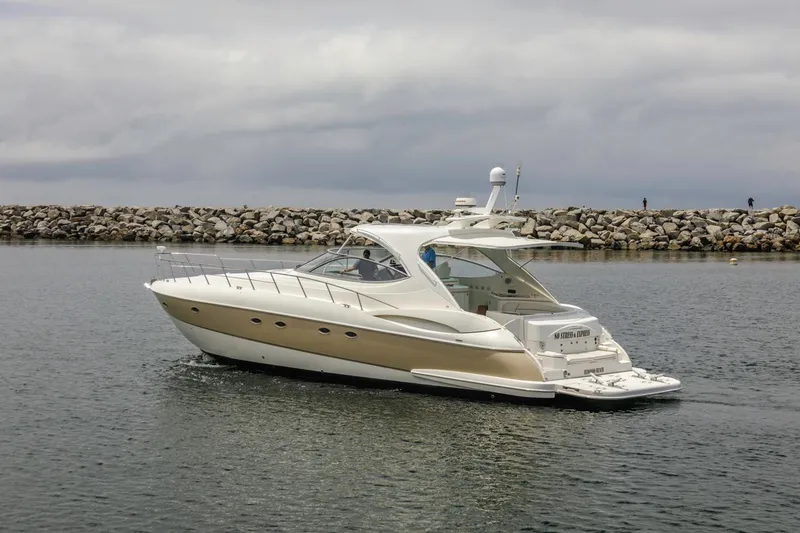 Slide: The Image of 2007 Cruisers Yachts 560 Express in calm waters near a rocky shoreline. - 4