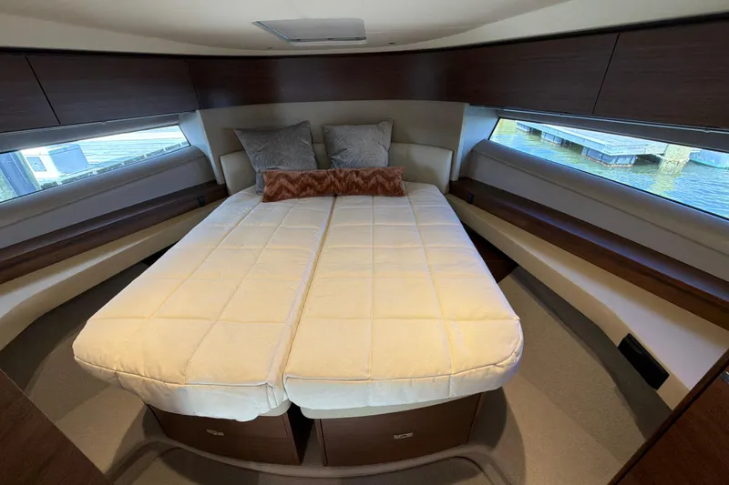 Slide: The Image of Luxurious cabin interior of 2027 Princess F50 yacht with cozy bedding and elegant wood finishes. - 98