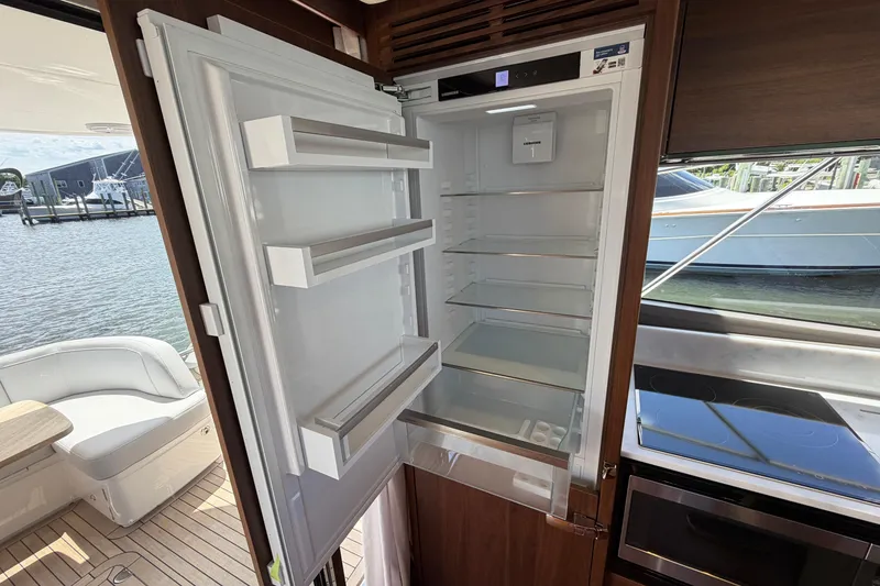 Slide: The Image of Open refrigerator inside a 2027 Princess F50 yacht, with modern kitchen and waterfront view. - 72