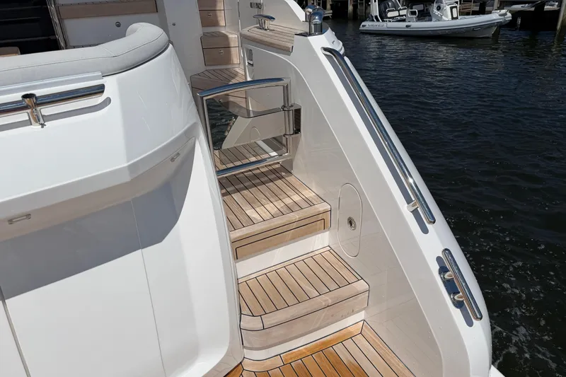 Slide: The Image of Elegant teak steps on a 2027 Princess F50 yacht, docked by the water. - 23