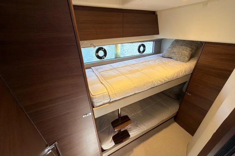 Slide: The Image of Luxurious 2027 Princess F50 yacht cabin with wooden interior and cozy bunk beds. - 107