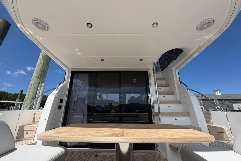 Slide: The Image of Luxurious 2027 Princess F50 yacht interior with wooden table and staircase under clear blue sky. - 37