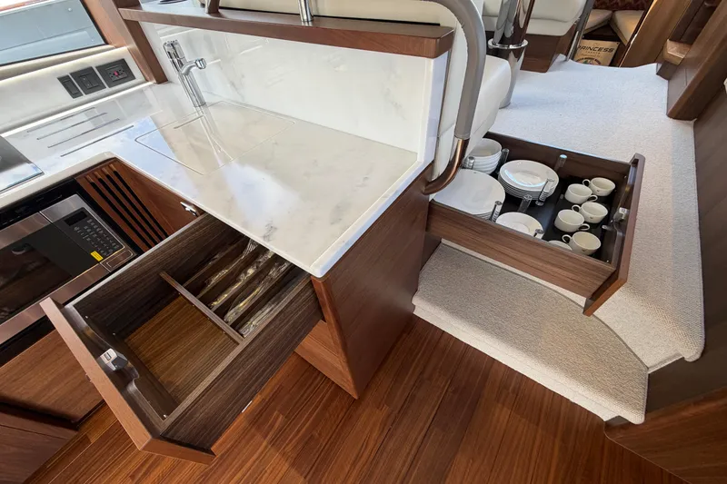 Slide: The Image of Luxurious kitchen area in 2027 Princess F50 yacht with modern cabinetry and elegant dish storage. - 76