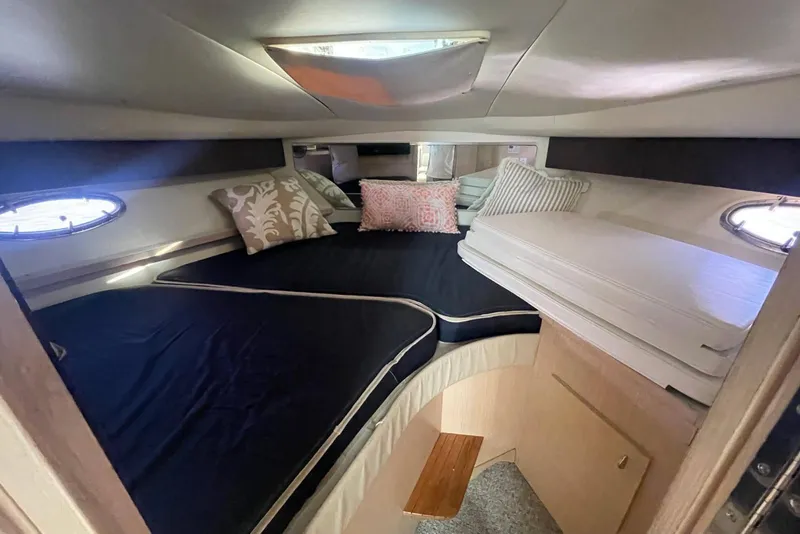 Slide: The Image of 1995 Tiara Yachts 3500 Express cabin interior with cozy bedding and porthole windows. - 12