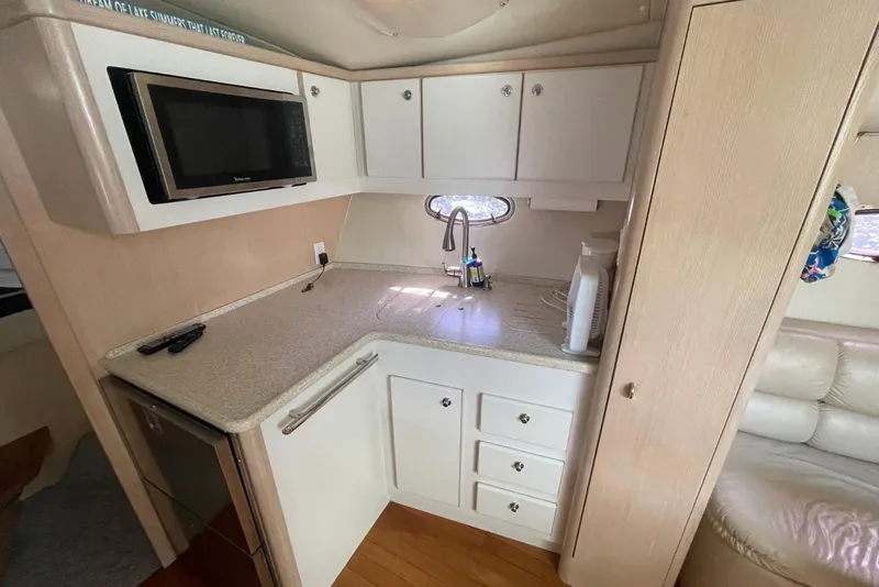 Slide: The Image of 1995 Tiara Yachts 3500 Express kitchen with microwave, sink, and storage cabinets. - 13