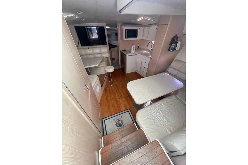 Slide: The Image of Interior of 1995 Tiara Yachts 3500 Express, featuring seating, table, and kitchenette. - 14