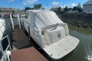 Slide: The Image of 1995 Tiara Express boat docked in a marina under a clear blue sky. - 2