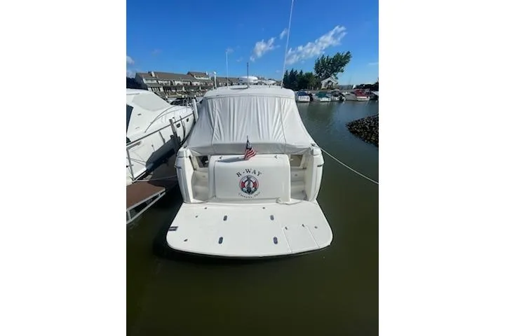 Slide: The Image of 1995 Tiara Express boat docked in marina, rear view with American flag. - 3
