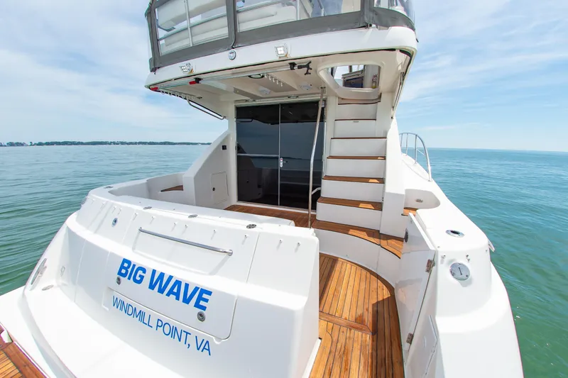 Slide: The Image of 2008 Sea Ray 47 Sedan Bridge yacht on water, featuring wooden deck and stairs. - 34