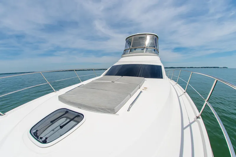 Slide: The Image of 2008 Sea Ray 47 Sedan Bridge yacht on calm water under blue sky. - 38