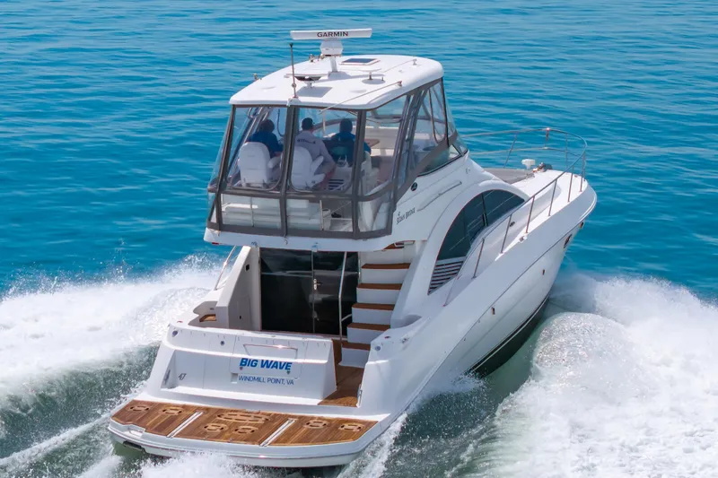 Slide: The Image of 2008 Sea Ray 47 Sedan Bridge yacht cruising on clear blue water. - 48