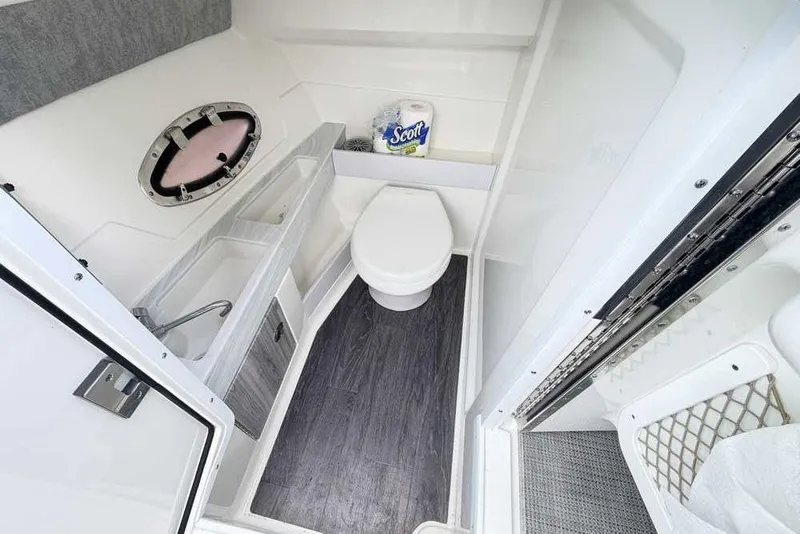 Slide: The Image of 2022 Formula 290 Bowrider bathroom with toilet, sink, and storage. - 8