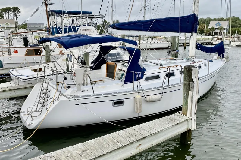 The Image of Sailboat docked at marina, 1991 Freedom 38 model, featuring blue canvas covers. - 0