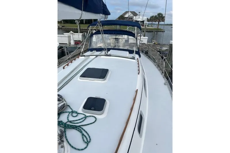 Slide: The Image of 1991 Freedom Yachts 38 sailboat docked, featuring a clean deck and blue canopy. - 1