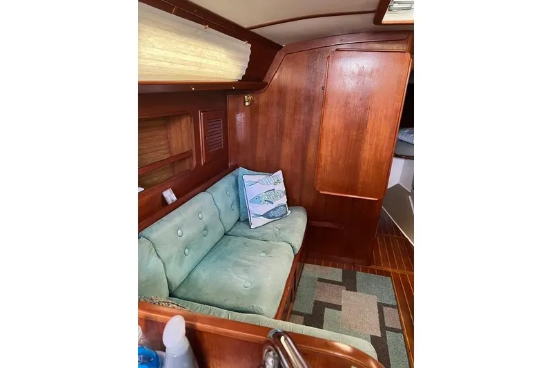 Slide: The Image of Interior of 1991 Freedom Yachts 38, featuring a cozy seating area with wooden accents. - 18
