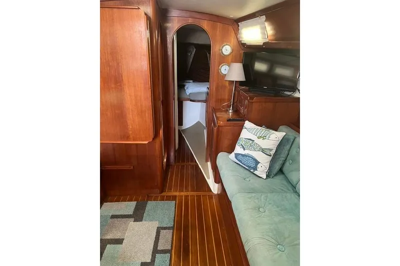 Slide: The Image of Interior of 1991 Freedom Yachts 38, featuring wooden paneling, cozy seating, and nautical decor. - 19