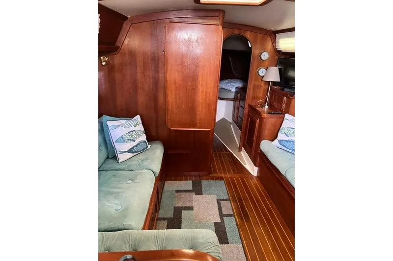Slide: The Image of Interior of 1991 Freedom Yachts 38, featuring wooden paneling and cozy seating. - 21
