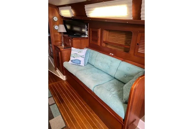 Slide: The Image of Interior of 1991 Freedom Yachts 38 with teal sofa and wooden cabinetry. - 22