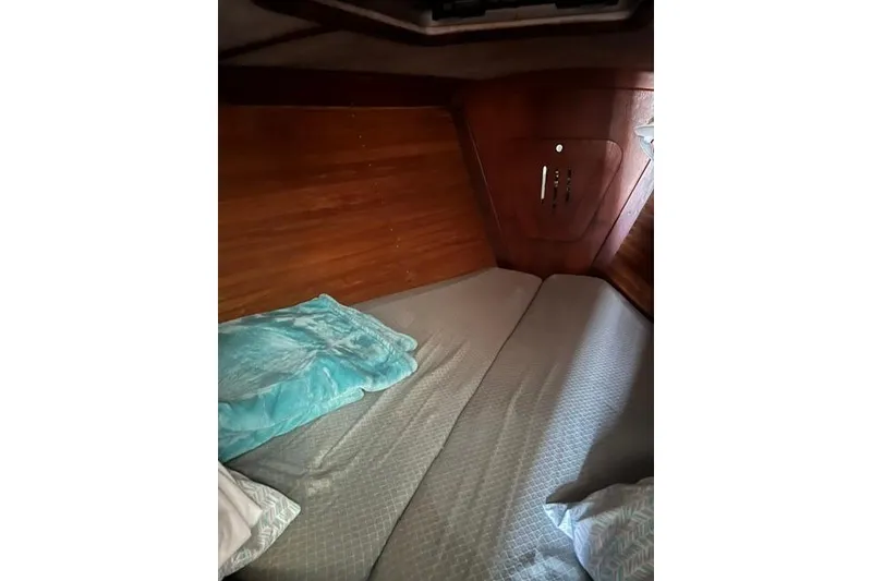 Slide: The Image of Cozy cabin interior of 1991 Freedom Yachts 38 with wooden paneling and bedding. - 23