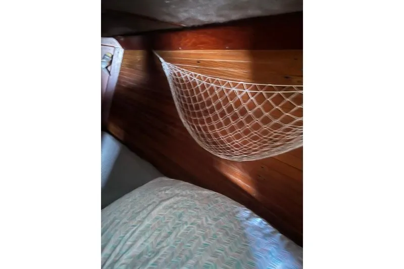 Slide: The Image of Interior of 1991 Freedom Yachts 38, featuring wooden paneling and a net storage area. - 24
