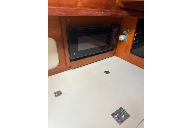 Slide: The Image of Microwave in 1991 Freedom Yachts 38 interior, wooden cabinetry, and white countertop. - 27