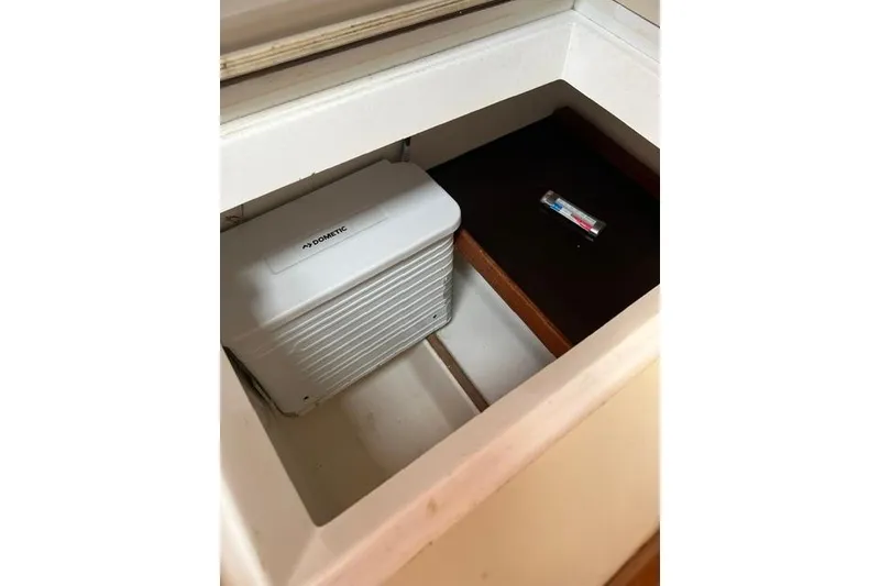 Slide: The Image of Storage compartment on 1991 Freedom Yachts 38, featuring a Dometic unit and a small item. - 28