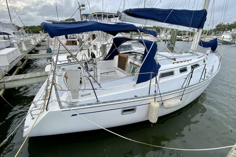 Slide: The Image of Sailboat Freedom 38, 1991 model, docked at marina with blue canopy and white hull. - 1