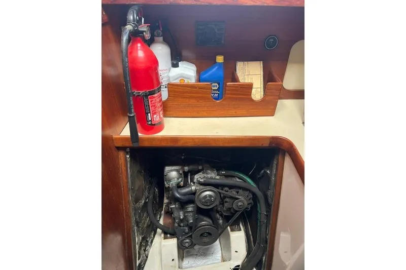 Slide: The Image of Engine compartment of a 1991 Freedom Yachts 38, featuring a fire extinguisher and maintenance supplies. - 31