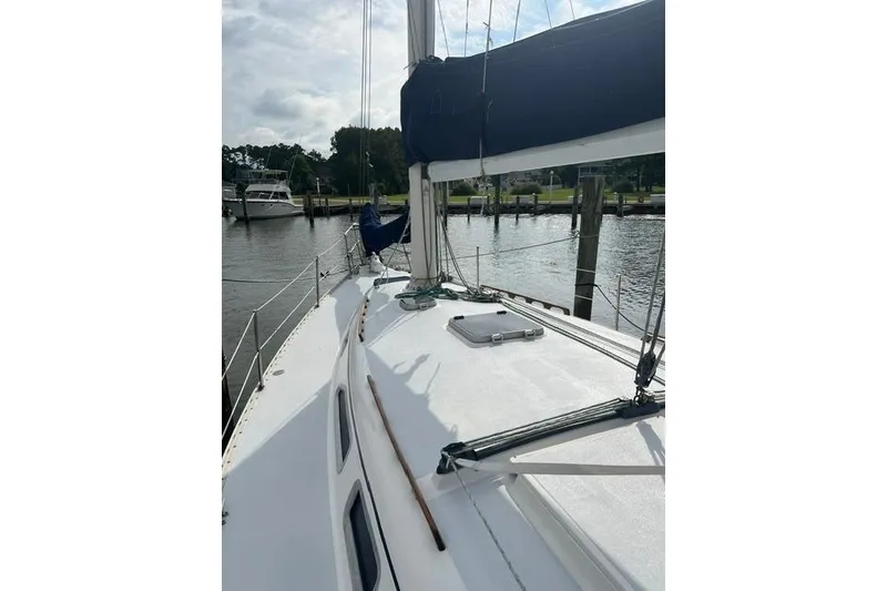Slide: The Image of 1991 Freedom Yachts 38 sailboat docked, showcasing deck and rigging under cloudy sky. - 4
