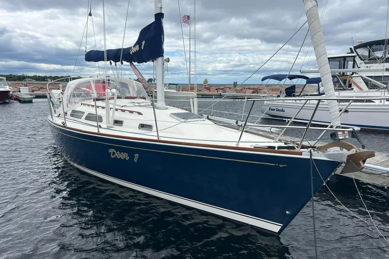 Slide: The Image of 1998 Sabre 362 sailboat docked in a marina, featuring a sleek blue hull. - 1